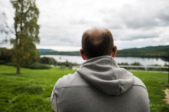 Mann med ryggen til i park