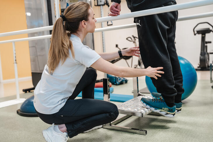 Fysioterapeut bistår med trening av legger Fysioterapeut bistår med trening av legger